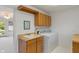 Laundry room with wooden cabinets, utility sink, washer, and dryer at 11415 Central E Dr, Carmel, IN 46032