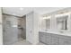 Bathroom featuring double vanity, framed mirrors, and a glass-enclosed shower at 11436 Mossy Ct # 101, Fishers, IN 46037