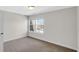 Clean, bright bedroom features neutral carpeting, a window, and freshly painted white walls at 11436 Mossy Ct # 101, Fishers, IN 46037