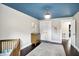Bedroom with crib, blue patterned ceiling, dresser, and patterned rug on the wood floors at 11626 Forest Dr, Carmel, IN 46033