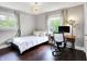 Bright bedroom features hardwood floors, a modern light fixture, and a desk area at 11626 Forest Dr, Carmel, IN 46033
