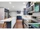 Modern kitchen with navy cabinets, stainless steel appliances, and a center island with bar seating at 11626 Forest Dr, Carmel, IN 46033