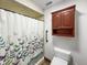Cozy bathroom featuring a patterned shower curtain, cabinet and comfort height toilet at 11642 Old Stone Dr, Indianapolis, IN 46236