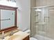 Well-lit bathroom featuring a vanity, large mirror, and glass-enclosed shower with tile surround at 11642 Old Stone Dr, Indianapolis, IN 46236