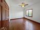 Bright bedroom with hardwood floors, a ceiling fan, and a large window at 11642 Old Stone Dr, Indianapolis, IN 46236