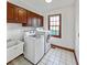 A bright laundry room with a washer, dryer, a sink, and ample cabinet space at 11642 Old Stone Dr, Indianapolis, IN 46236