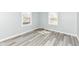 Sunny bedroom featuring grey walls, white trim, and light wood-look flooring at 1216 N Whittier Pl, Indianapolis, IN 46219