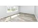 Bright living room featuring stylish gray wood flooring and a large window at 1216 N Whittier Pl, Indianapolis, IN 46219