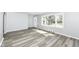 Bright living room boasts gray wood floors, a large window, and modern gray walls at 1216 N Whittier Pl, Indianapolis, IN 46219