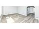 Open-concept living space with gray wood floors and arched doorway at 1216 N Whittier Pl, Indianapolis, IN 46219
