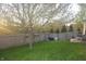 Spacious backyard surrounded by a wooden fence with green lawn, a mature tree and patio seating at 12214 Cold Stream Rd, Noblesville, IN 46060