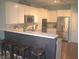 Eat-in kitchen with a breakfast bar featuring updated stainless steel appliances and white cabinets at 12214 Cold Stream Rd, Noblesville, IN 46060