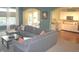 Open-concept living room flowing into the kitchen, featuring a gray sectional sofa and lots of natural light at 12214 Cold Stream Rd, Noblesville, IN 46060