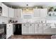 Updated kitchen showcasing white cabinets, countertops, sleek, black appliances, and modern fixtures at 123 Thistlewood Dr, Greenfield, IN 46140