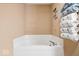 Bright bathroom showcasing a corner tub with a tiled surround and a rack of fresh, neatly folded towels at 132 Thistlewood Dr, Greenfield, IN 46140