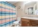 Bathroom features a sink, toilet, shower with a colorful curtain, and a wall mirror, providing essential amenities at 132 Thistlewood Dr, Greenfield, IN 46140