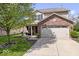 Charming home with a brick front, attached two-car garage and mature tree in the front yard at 132 Thistlewood Dr, Greenfield, IN 46140