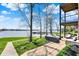 Relaxing outdoor area with lake views, patio and outdoor furniture, and path with covered seating on a sunny day at 13797 E Southshore Dr, Fishers, IN 46037