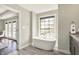 Freestanding tub with large window and view, next to dual vanity sinks and access to balcony at 13797 E Southshore Dr, Fishers, IN 46037