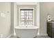 Modern free-standing bathtub with view of outdoor scenery through large window at 13797 E Southshore Dr, Fishers, IN 46037