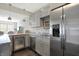Well-lit kitchen showcasing gray cabinets, stainless steel refrigerator, and granite countertops at 13797 E Southshore Dr, Fishers, IN 46037