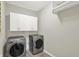 Bright laundry room featuring front load washer and dryer, white cabinets, and a wire shelf at 13797 E Southshore Dr, Fishers, IN 46037