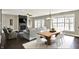 Open-concept living and dining area featuring a stone fireplace, modern lighting, and large windows at 13797 E Southshore Dr, Fishers, IN 46037