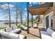 Lake view showing outdoor lounge furniture, patio and adjacent lawn with lake access on a sunny day at 13797 E Southshore Dr, Fishers, IN 46037