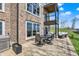 Brick patio and building showing second story balcony, patio furniture, hot tub, and lawn at 13797 E Southshore Dr, Fishers, IN 46037
