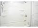 Bright white bathroom with tub/shower combo, built-in shelving, and updated fixtures, creating a modern and clean space at 1410 E 75Th St, Indianapolis, IN 46240