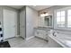 Bathroom featuring wood-look floors, a tiled tub, granite countertop, and a bright window at 14386 Salem E Dr, Carmel, IN 46033