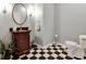Elegant powder room featuring a vanity with vessel sink, black and white checkered flooring, and stylish accents at 14386 Salem E Dr, Carmel, IN 46033