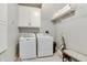 Bright laundry room with modern washer and dryer, storage cabinet, and convenient shelving at 14386 Salem E Dr, Carmel, IN 46033