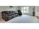 Cozy living room features a leather sofa, massage chair, and ample natural light for comfortable living at 14386 Salem E Dr, Carmel, IN 46033