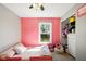 Bright bedroom with pink walls, ceiling fan, and window overlooking the front yard at 14429 Banister Dr, Noblesville, IN 46060