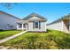 Charming single-story home featuring a red front door, well-kept lawn and complementary landscaping at 14429 Banister Dr, Noblesville, IN 46060