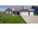 Charming brick home with a well-manicured lawn, two-car garage, basketball hoop and covered front porch at 15142 Blue Ribbon Blvd, Fishers, IN 46040