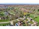 Wide aerial view of a neighborhood featuring tree-lined streets, manicured lawns, and nearby golf course at 168 Yorkshire W Blvd, Cumberland, IN 46229