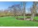 Beautifully landscaped backyard featuring a swing set, mature trees, and well-manicured lawn at 168 Yorkshire W Blvd, Cumberland, IN 46229