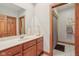 Bathroom features a wood vanity, mirror, and shower with neutral finishes and white tile at 168 Yorkshire W Blvd, Cumberland, IN 46229