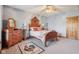Cozy bedroom featuring a wood bed frame, vintage dresser, decorative rug, and ceiling fan at 168 Yorkshire W Blvd, Cumberland, IN 46229
