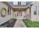 Charming front porch with a decorative wreath, rocking chair, and blooming flowers at 168 Yorkshire W Blvd, Cumberland, IN 46229