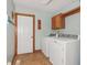 The laundry room is equipped with a washer, dryer, and overhead cabinets for storage solutions at 168 Yorkshire W Blvd, Cumberland, IN 46229