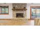 Stone fireplace with a wood mantle and accessories in a bright living room with light wood flooring at 168 Yorkshire W Blvd, Cumberland, IN 46229