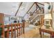 Open-concept living room with wood beam accents, stone fireplace, and staircase at 168 Yorkshire W Blvd, Cumberland, IN 46229
