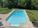 Outdoor pool with surrounding concrete deck and landscaped border on a sunny day at 168 Yorkshire W Blvd, Cumberland, IN 46229