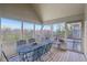 Screened porch with vaulted ceiling and a metal table and chairs surrounded by scenic views at 168 Yorkshire W Blvd, Cumberland, IN 46229