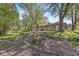 Rear exterior showcasing stone details, a lush lawn, a fire pit, and mature trees at 1710 S Butler Ave, Indianapolis, IN 46203