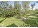 View of the outdoor space featuring mature trees and a worn basketball court at 1710 S Butler Ave, Indianapolis, IN 46203