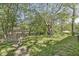 Grassy backyard surrounded by mature trees and wooden fence creating a nature escape at 1710 S Butler Ave, Indianapolis, IN 46203